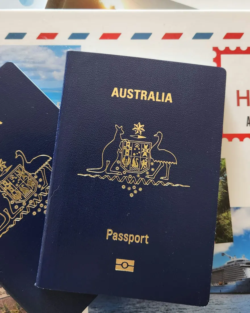 Two Australian passports resting on travel brochures