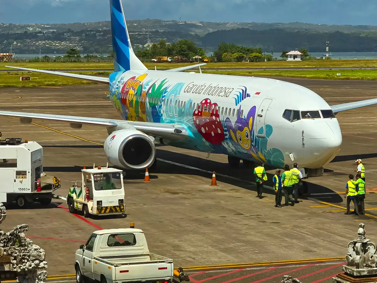 Ground crew beside a Garuda Indonesia aircraft at Denpasar airport