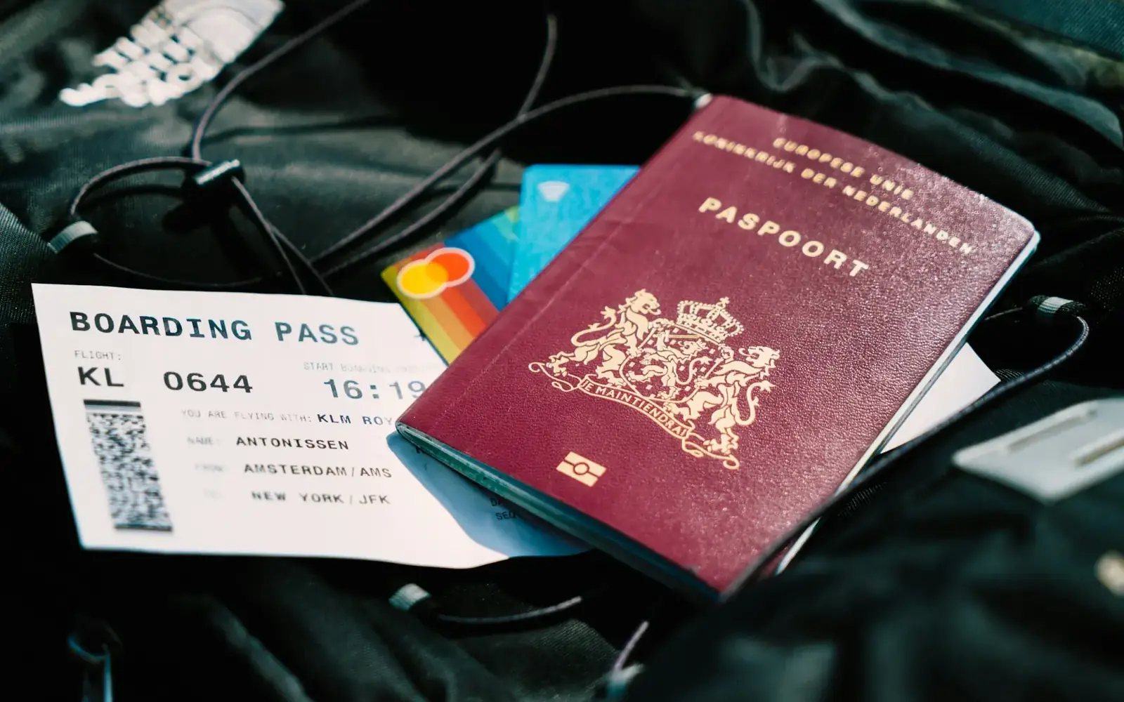 Passport, boarding pass and cards laid on a travel bag