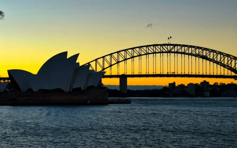 Sydney Opera House and Harbour Bridge silhouetted at sunset