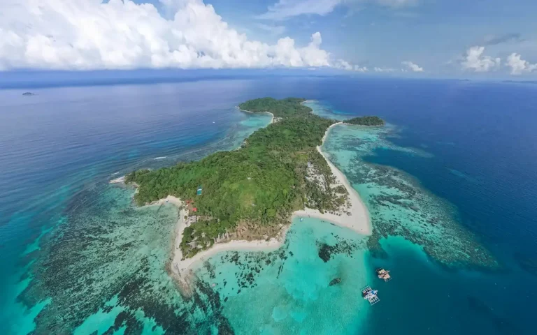 Aerial view of a tropical island ringed by a turquoise reef