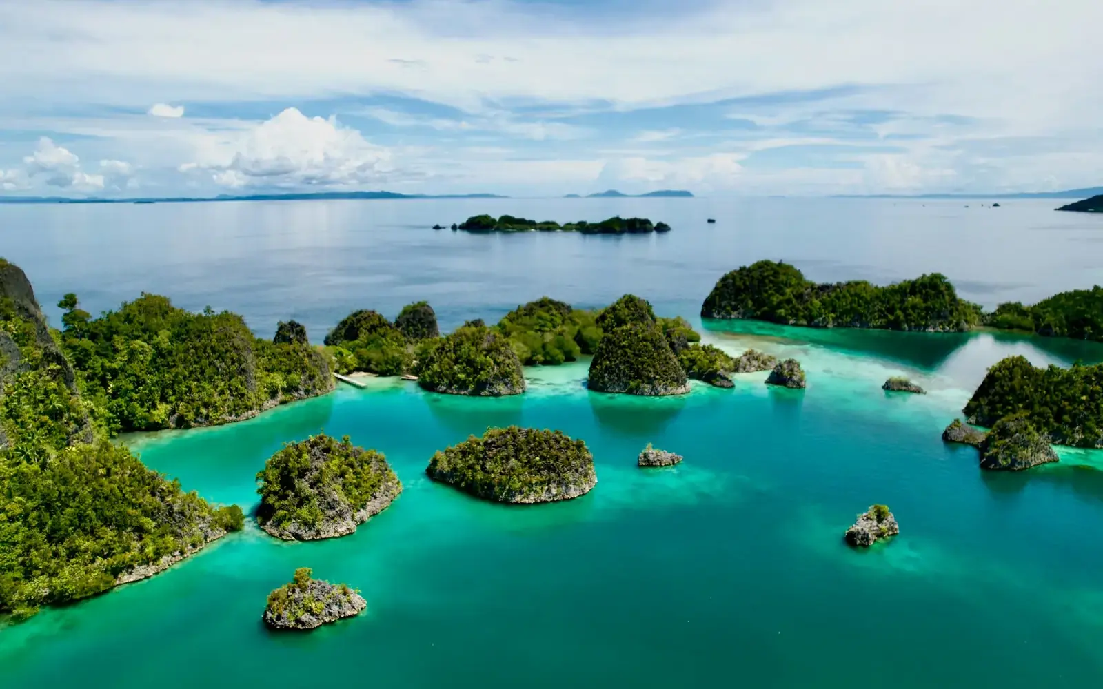 Aerial view of green limestone islands in a turquoise lagoon