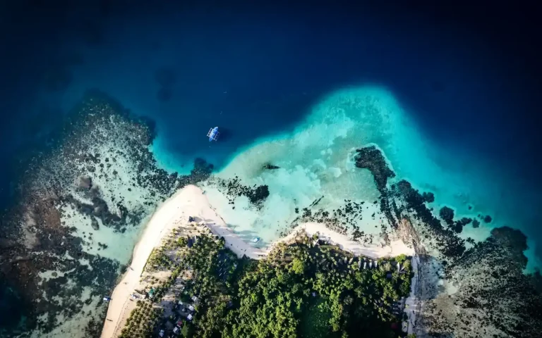 Drone view of a coral reef and white sand island