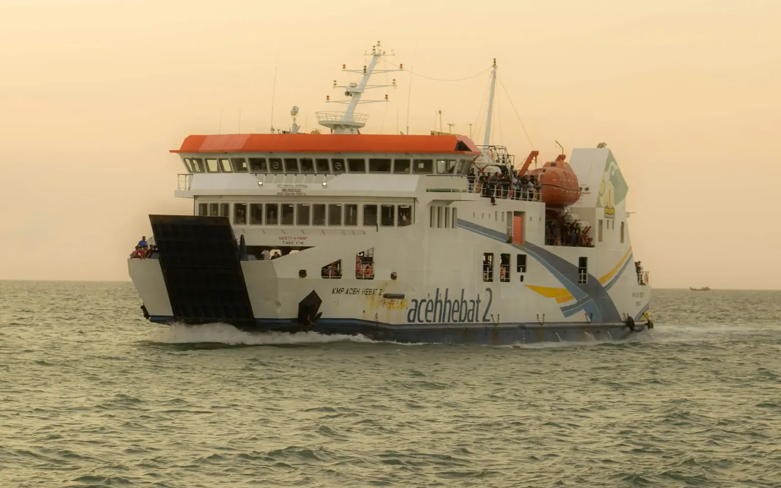 Passenger ferry crossing calm seas at sunset in Indonesia