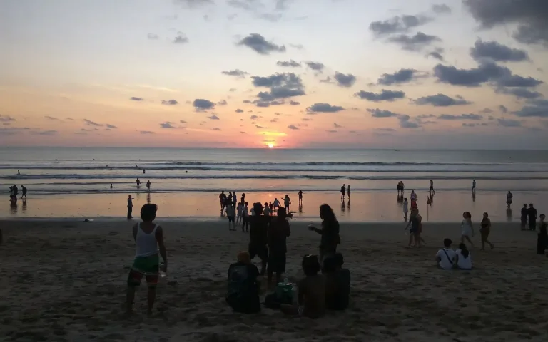 Sunset over Kuta Beach with people on the sand